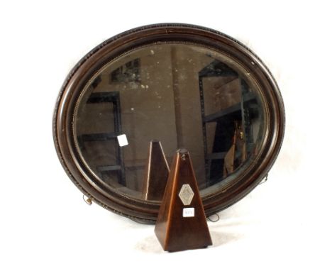 An oval wall mirror and a metronome