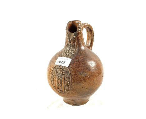 A 17th Century Belamine bottle with mask and coat of arms, top rim loss, height 8"