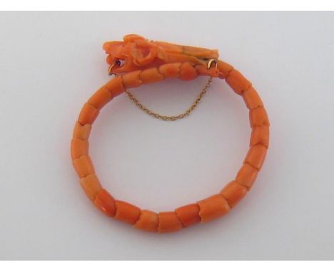 A coral bangle, modelled as a dragon, composed of articulated coral links, 5.3cm inner diameter, 21.5gms 