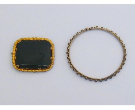 A ruby bangle, set around its circumference with small round cuts, 2.8mm wide, mounted in yellow metal (tests 14 carat), 9.7g