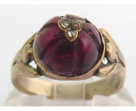 A 19th century silver, garnet and diamond dress ring, the high domed garnet set to the apex with a trefoil of rose cuts, to b