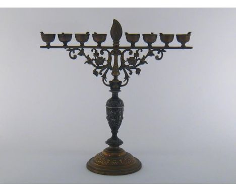 Judaica. A brass and white metal chanukia with embossed brass base, cast white metal baluster central section and cast brass 