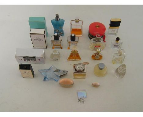 A group of 24 perfume bottles and atomisers, approximately 9 with part contents (3 in original boxes) and an Yves St. Laurent