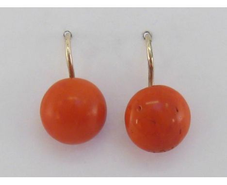 A pair of coral earrings, the circular button cabochon stones 11.6mm diameter, to yellow metal hook fittings, with French 14 