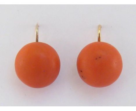 A pair of coral earrings, the circular button cabochon stones 15.6mm diameter, to yellow metal (tests 14 carat gold) hook fit
