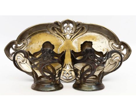 Zwei Teeglashalterungen, WMF. Metall, versilbert. Entwurf von Theodor Radivon. Straußenmarke WMF, um 1900. H. 8 cm. Beigegebe