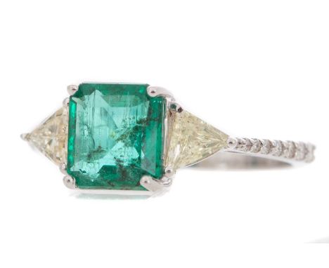 set with an octagonal step cut emerald of approximately 1.65 carats, flanked by trillion cut diamonds, on diamond shoulders, 