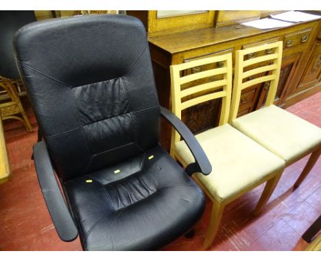 Black upholstered office chair on a swivel base and two light wood dining chairs