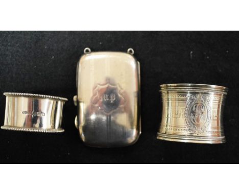 A silver rounded rectangular cigarette case, engine turned, gilt lined, Birmingham 1914; two silver napkin rings, 109g gross 
