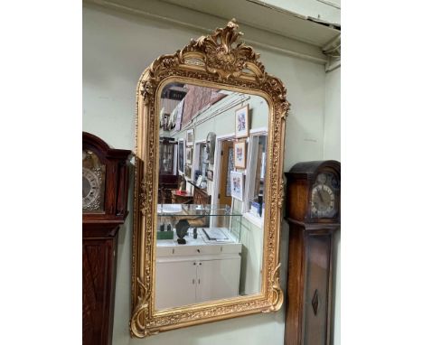 Rectangular gilt framed bevelled wall mirror with swag and floral crest, 156cm by 85cm.