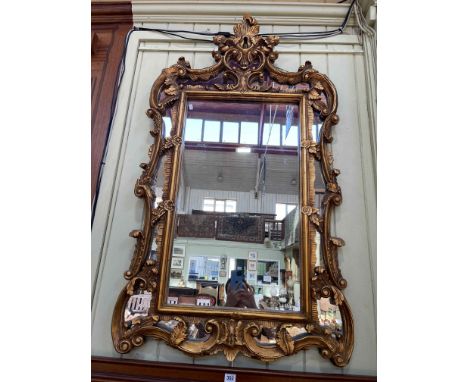 Ornate gilt framed marginal wall mirror, 127cm by 72.5cm.
