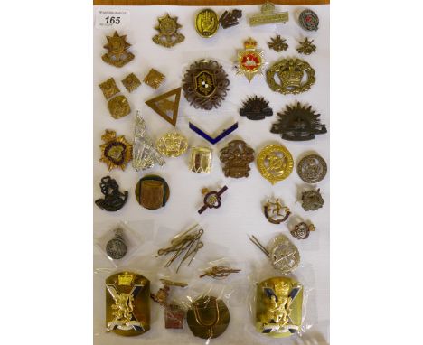 A collection of approx thirty two cap badges from the First World War onwardsTo include silver George V services rendered bad