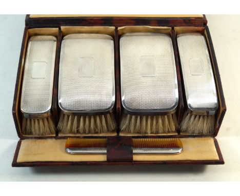 A George V hallmarked silver five piece vanity setComprising four brushes and one comb, each having hallmarked silver mounts 