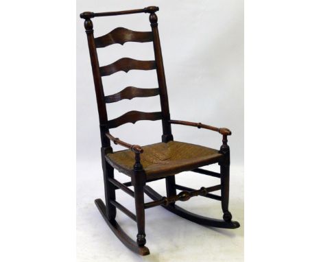 A 19th Century Macclesfield oak ladder back rocking chairFeaturing the characteristic top rail above a rush seat flanked by o