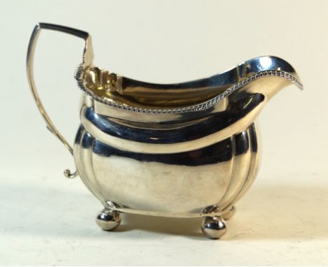 A George III hallmarked silver cream jugOf plain square form, having cast beaded rim, raised on four ball feet, makers marks 