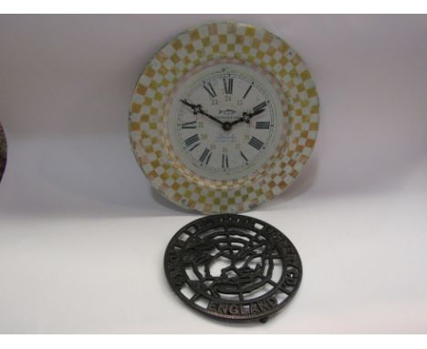 A Howdens Joinery iron pot stand together with a Roger Lascelles tin clock "La Poissonnerie" No. 7, 34cm diameter 