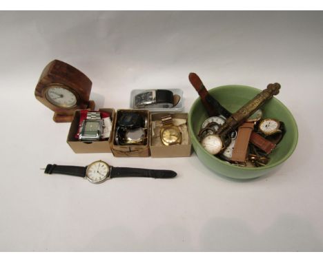 A box containing various watches and a small bedside clock etc 
