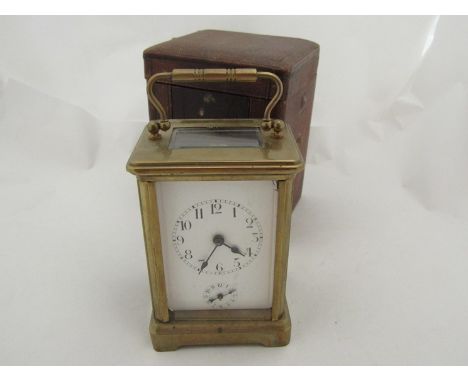 A late 19th early 20th Century brass carriage clock with alarm, red case a/f 