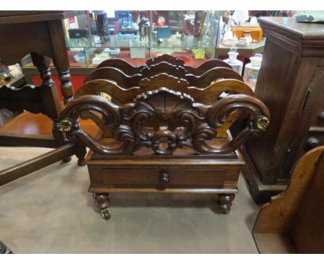A 19th Century rosewood three division Canterbury with carved decoration over a single base drawer over turned and tapering l