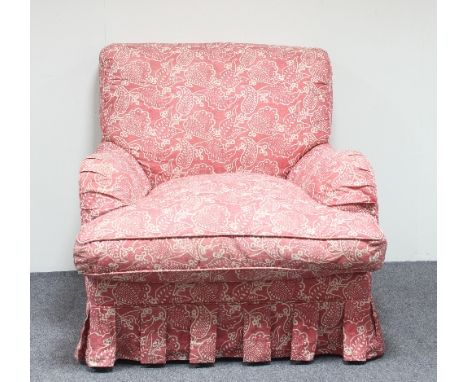 A modern upholstered armchair in leaf print fabric