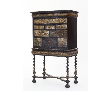 A Charles II engraved, silver-foil and ebonised cabinet-on-stand, decorated to the front with silver-foil panels, possibly re