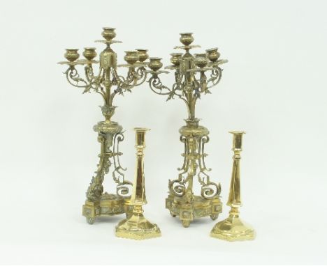 A pair of late Victorian brass five-light candelabra with foliate decoration to the scroll branches and pierced tripod base, 