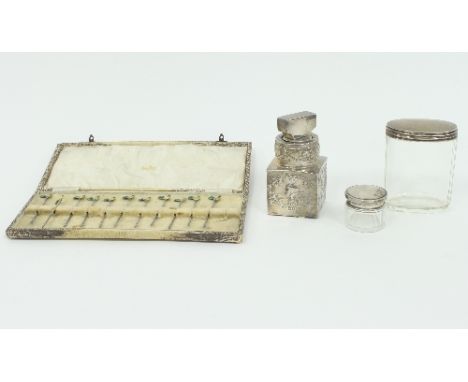 A silver mounted scent bottle, William Comyns, London 1904, decorated cherubs, two silver mounted glass jars and a set of twe