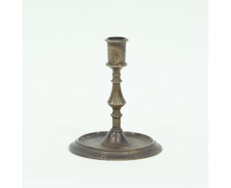 A 17th Century style brass candlestick, with baluster stem on a circular foot, 16.5cm high