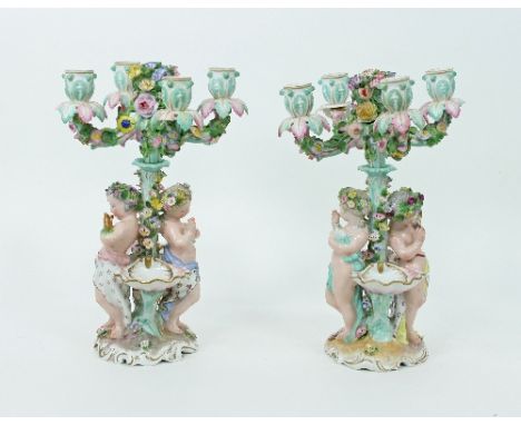 A large pair of 19th Century porcelain four-light candelabra, with imitation Meissen marks, encrusted with flowers, each with