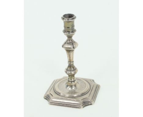 A George II silver taper stick, possibly Ambrose Stevenson, London 1729, of knopped form on a square base with concave corner