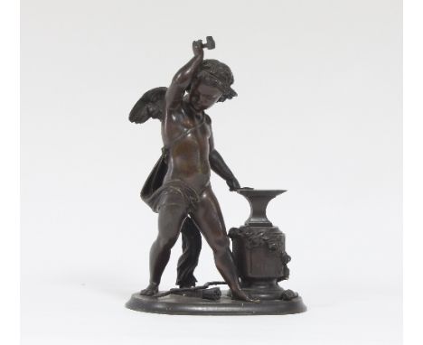 A 19th Century bronze figure of Cupid at his forge, shaping an arrowhead on an anvil, his bow at his feet, 26cm high