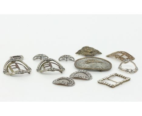A collection of buckles, including a pair of Georgian white metal buckles, a Georgian white paste and silver buckle, a pair o
