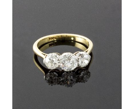 A three-stone diamond ring, the graduated stones claw set to an 18ct yellow gold shank, ring size L/see illustration