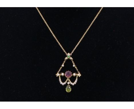 An Edwardian peridot, pink tourmaline and half pearl pendant, of scroll and swag design, claw set with a circular cut tourmal