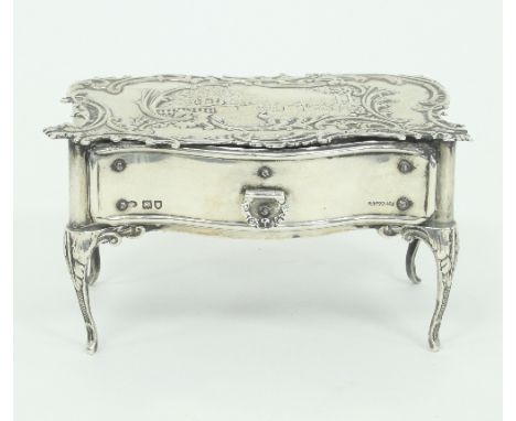 A silver trinket box, William Comyns, London 1903, in the form of a French serpentine front table, the top embossed a garden 