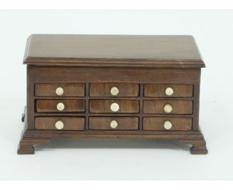 A George III style apprentice chest, with hinged cover above three rows of three short drawers on ogee bracket feet, 21.5cm w