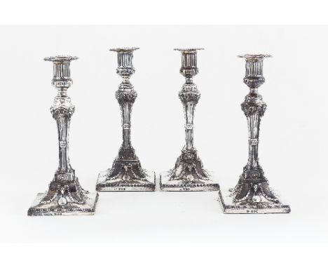 A set of four George III silver candlesticks, John Carter, London 1774, the fluted sconces with a band of Greek key decoratio