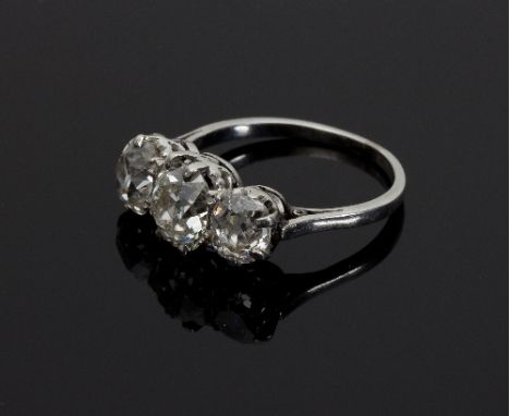 A three-stone diamond ring, claw set with old mine cushion shaped diamonds, the largest at the centre/see illustration