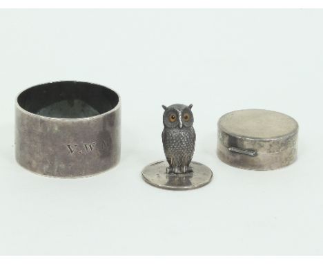 A silver owl menu holder, S M and Co, Chester 1912, a silver napkin ring and a circular silver box