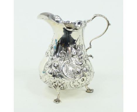 A silver jug, marks rubbed but circa 1800, of pear shape with scroll handle and later embossed decoration, 13.5cm high, appro