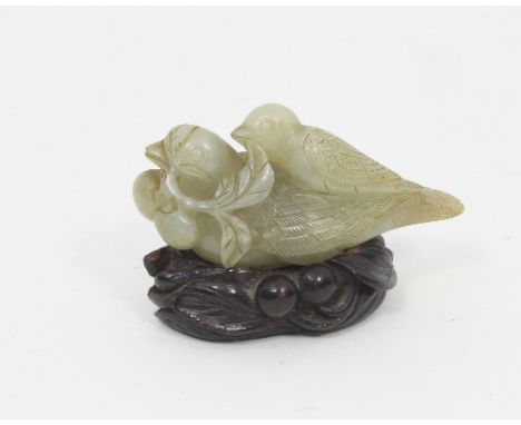 A jade figure of a bird, a sprig with berries in its mouth and a chick on its back, with wooden stand Condition Report: Celad