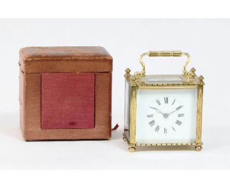 A gilt brass cased carriage clock, the white enamel dial with Roman numerals in a rectangular case with finials to the corner