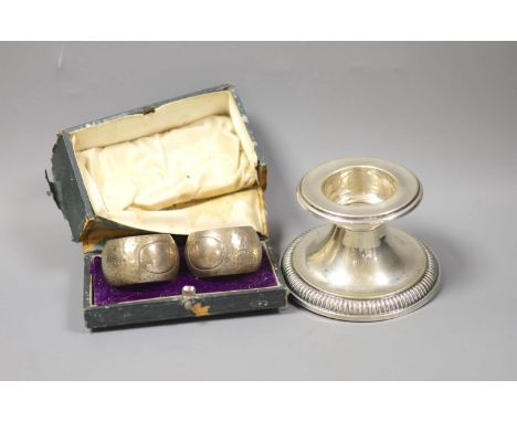 A German white metal dwarf candlestick and a cased pair of silver napkin rings by Walker &amp; Hall.