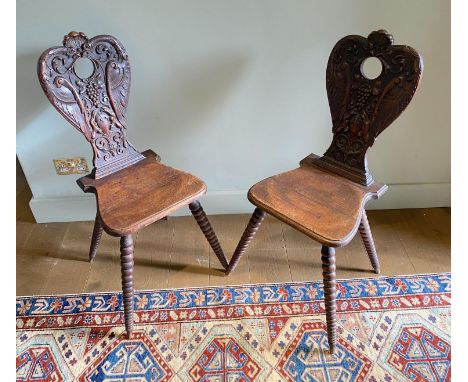 A pair of 19th century Swiss carved oak hall chairs, with vine and scroll backs and tapered bobbin turned legs, width 55cm he