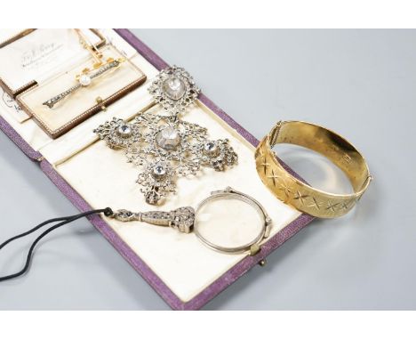 A white metal and paste set drop pendant, 10.7cm, a modern silver gilt bangle, a 9ct gold bar brooch, two other brooches and 