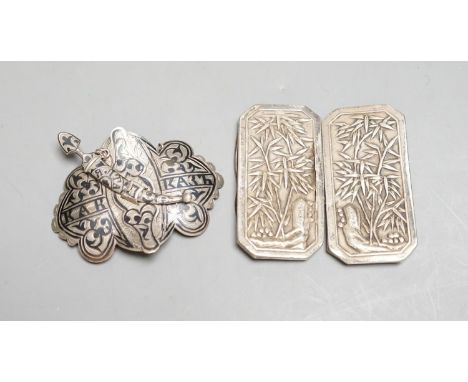 A Chinese white metal belt buckle by Wang Hing(a.f.)68mm and a Russian silver and niello work belt buckle.