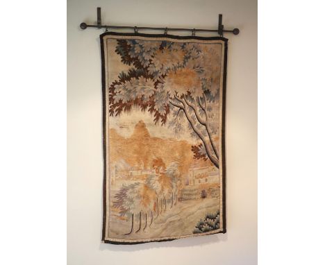 A French tapestry wall hanging, decorated with a town and trees, 125 x 79cm, with associated wrought iron hanging rail