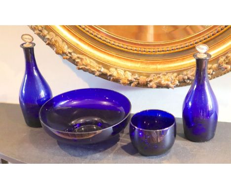 A pair of Bristol blue glass decanters with mother of pearl stoppers, height 28cm, a bowl, diameter 25cm and a finger bowl, d