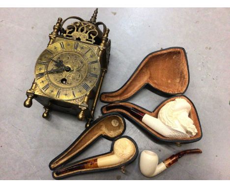Three cased meerschaum pipes, together with a 17th century style brass lantern clock