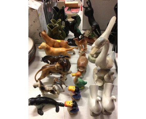 Group of animal ornaments including three fish glug jugs, Beswick dog, pair of Nao doves and Guinness toucan salt and pepper 